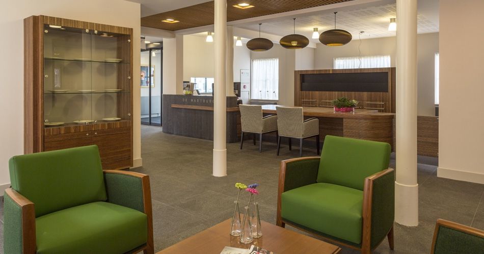 Plexwood® De Wartburg Care Hotel round entrance reception desk with table, storage and display cabinet in meranti