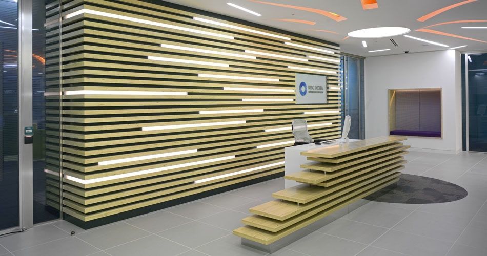 Plexwood® RBC Investor Services bank relief wall with incorporated lights and reception desk in poplar comprised surface plywood